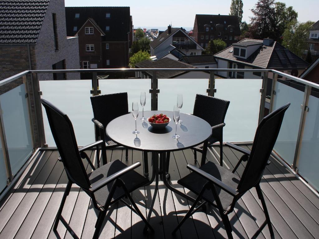 a table with chairs and a bowl of fruit on a balcony at Sonnengarten 21 in Kellenhusen