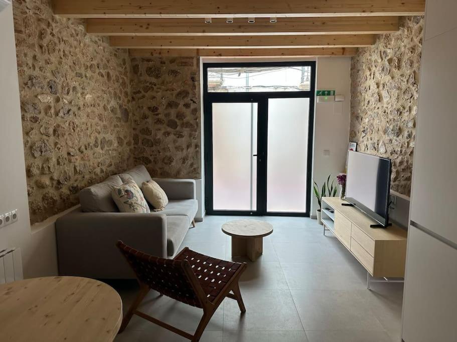 a living room with a couch and a tv at Ca Tono Casa Rural in Les Coves de Vinroma