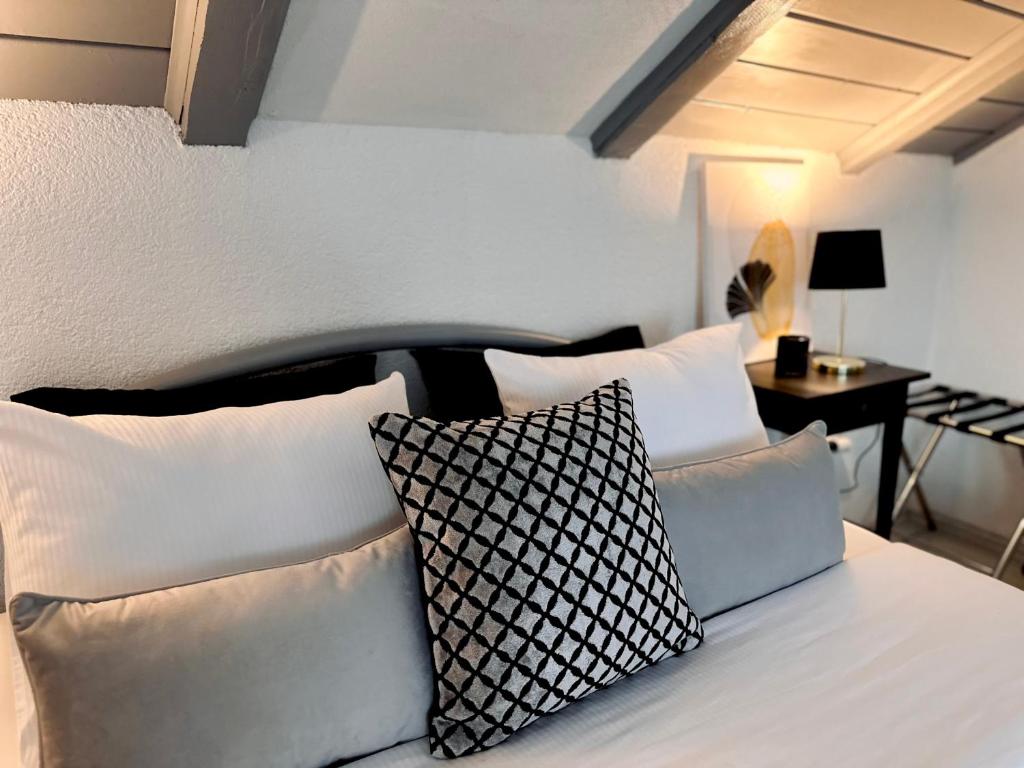 1 dormitorio con cama con almohadas blancas y mesa en Rooms Mirabella, en Rakovica