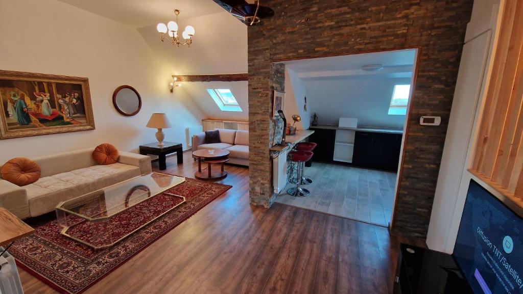 a living room with a couch and a brick wall at La Cigogne in Château-Thierry