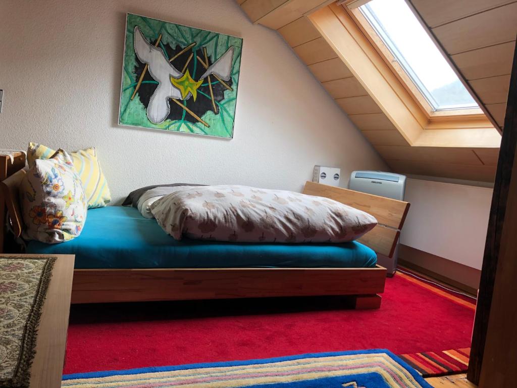 ein Schlafzimmer mit einem Bett im Dachgeschoss mit einem Fenster in der Unterkunft Privatzimmer im 2. OG (Mansarde) mit Klimaanlage und schnellem Telekom-WLAN in Einfamilienhaus in Winningen