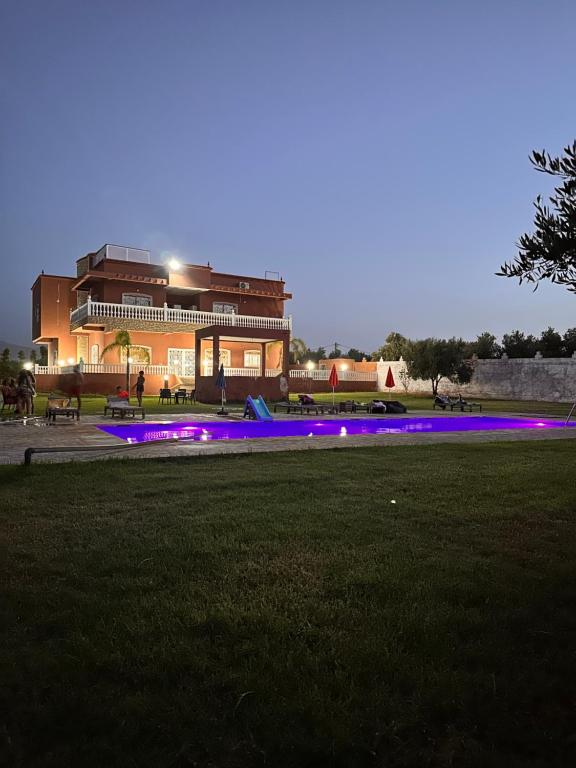 un edificio con luces púrpuras frente a un campo en AYOR FES, 