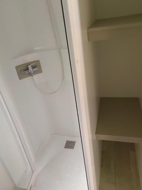ein kleines Bad mit einem WC und einem Regal in der Unterkunft Paisible in Agde