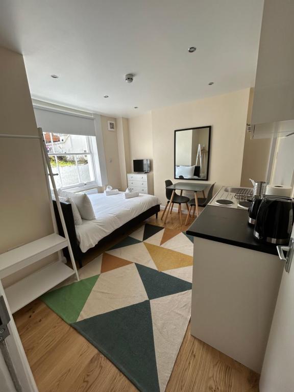 a kitchen and living room with a bed in a room at Flat 1, 128A Belsize Road NW6 4BG LONDON in London