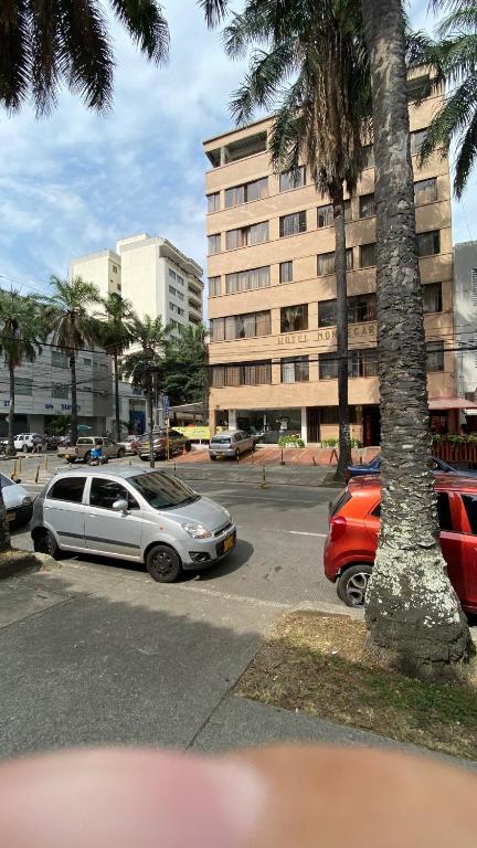 a parking lot with cars parked in front of a building at Hotel Montecarlo in Cali