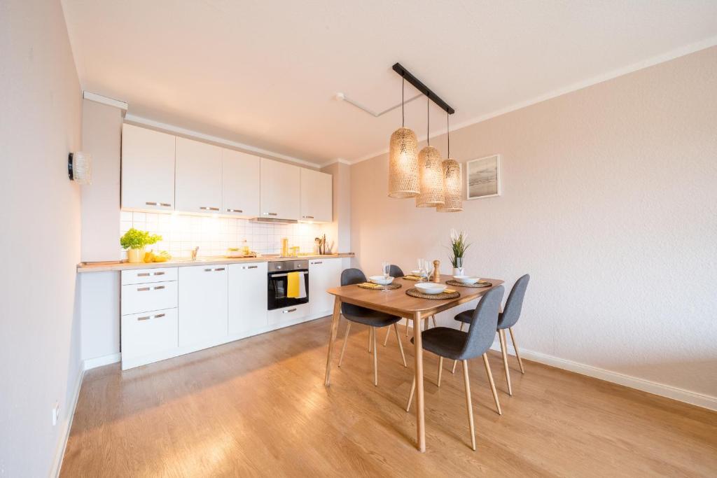 a kitchen and dining room with a wooden table and chairs at CNS-b-4-21 - 2-Raum Appartement BalkonGarten in Cappel-Neufeld
