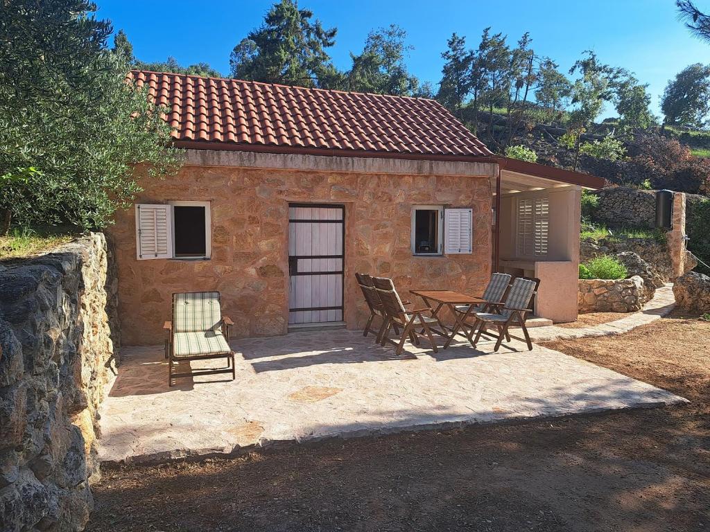 a house with a table and chairs in front of it at Mala oaza in Vrisnik