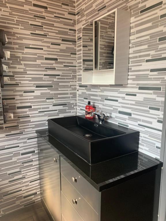 a bathroom with a black sink and a mirror at Family Holiday Home in Blackpool