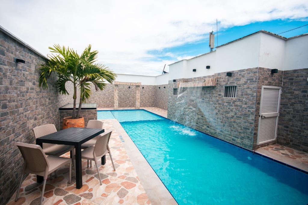 a pool with a table and chairs next to a building at Hotel Buddha Mystic By Del Toro in Doradal