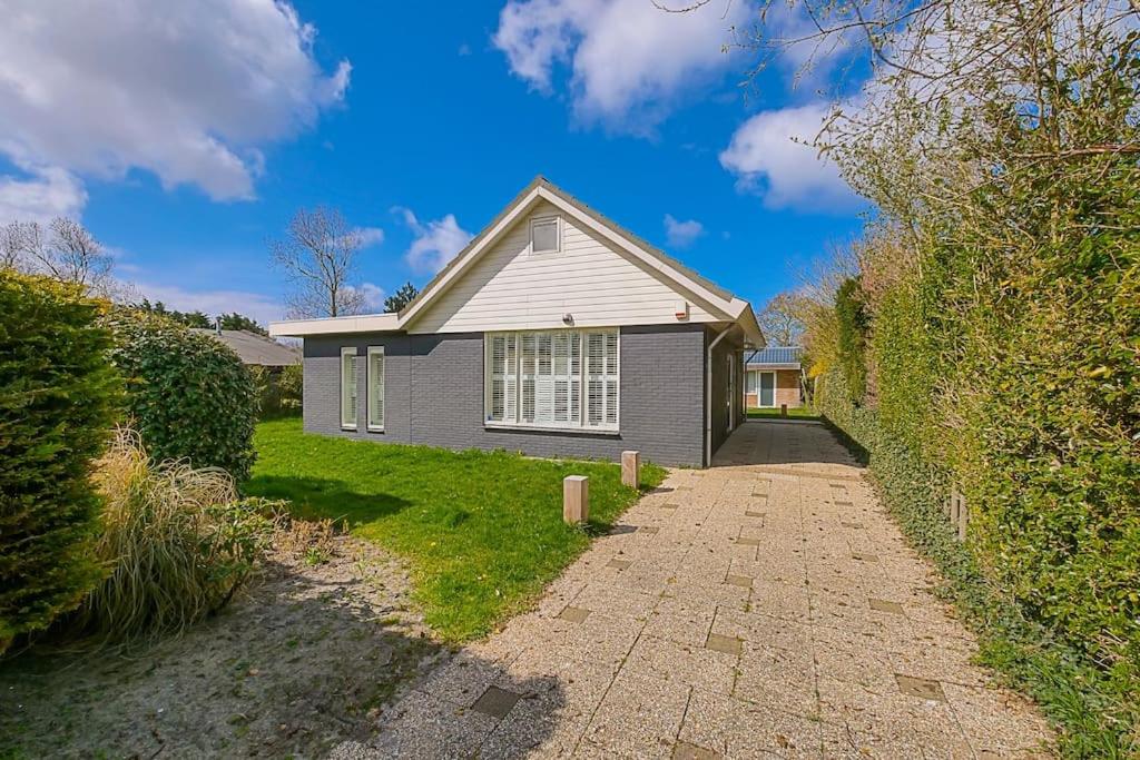 una pequeña casa con una entrada delante de ella en Vakantiehuis Duyngans - Julianadorp aan Zee, en Julianadorp
