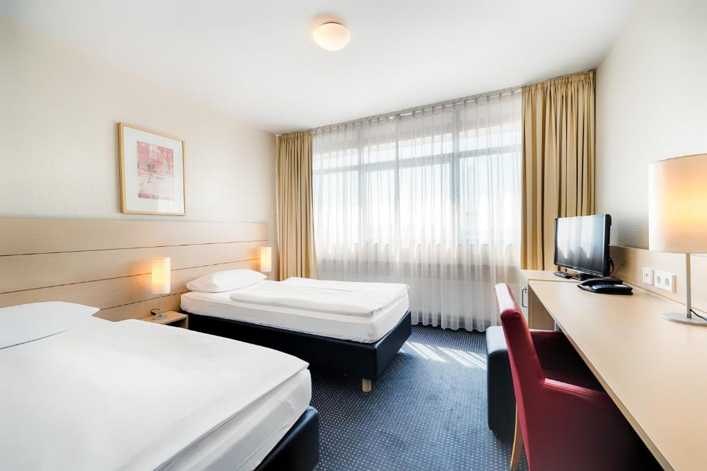 a hotel room with two beds and a television at Enjoy Hotel am Studio in Berlin