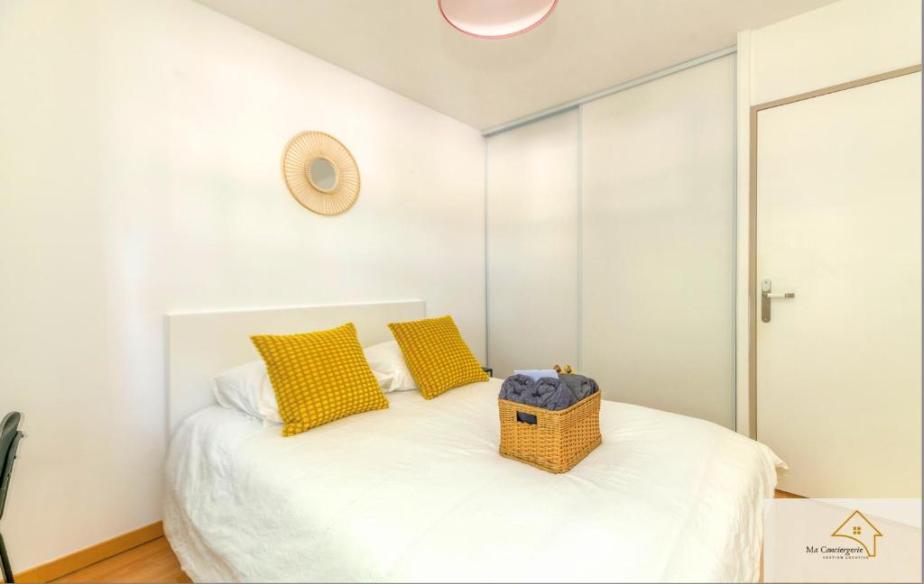 a bedroom with a bed with yellow pillows and a mirror at Le Mykonos¶ Gare¶ 2Garages ¶Jardin ¶Spacieux in Grenoble
