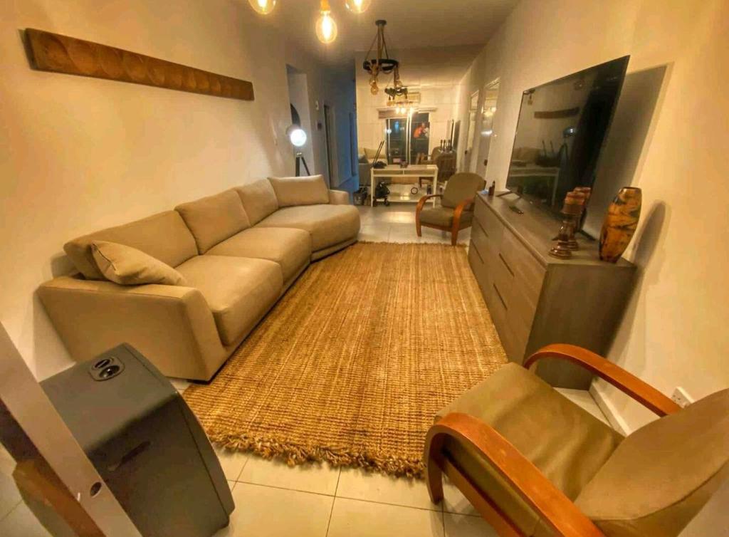 Modern 3BDR in Acropolis-Nicosia في Strovolos: غرفة معيشة مع أريكة وتلفزيون بشاشة مسطحة