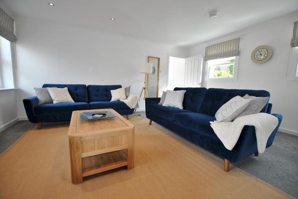 a living room with two blue couches and a coffee table at Murrays Neuk- stylish coastal apartment in Anstruther