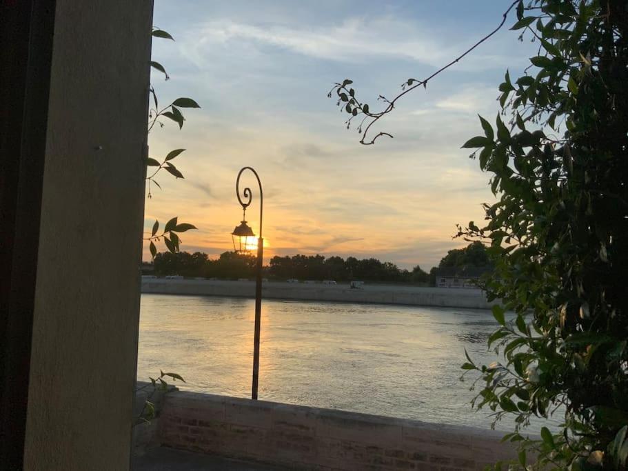 un feu de rue avec le coucher du soleil en arrière-plan dans l'établissement Maison charmante au bord du Rhône., à Arles