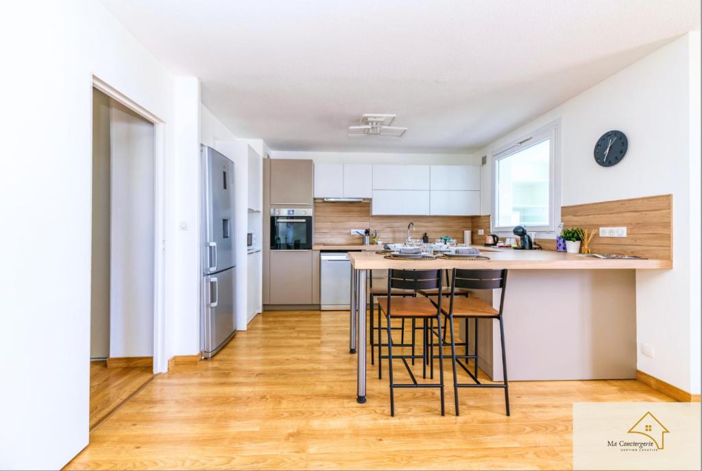 a kitchen with a table and chairs in a room at Le Mykonos¶ Gare¶ 2Garages ¶Jardin ¶Spacieux in Grenoble