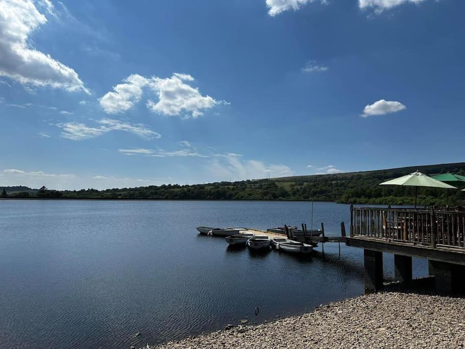 a dock with boats on a large body of water at Large Peak District National Park Holiday House in Hadfield