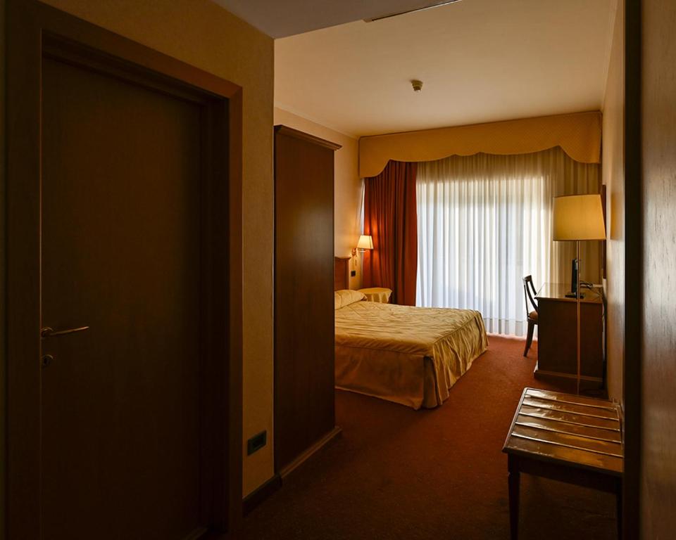 Villa Sirena Hotel e Ricevimenti في Durazzano: غرفه فندقيه بسرير ونافذه