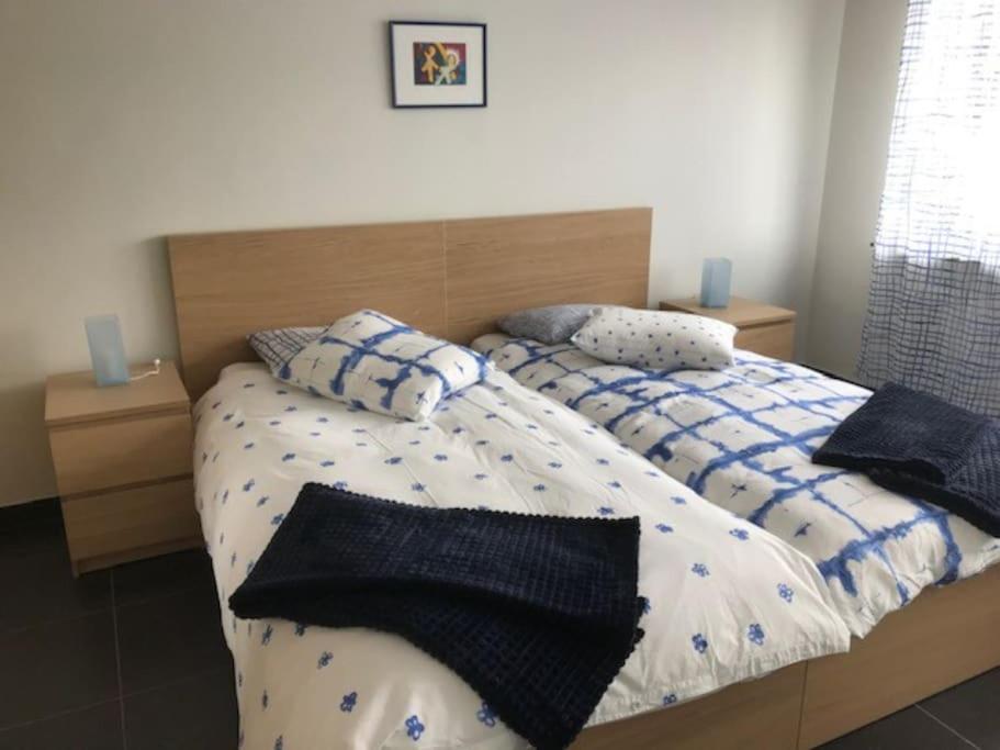 a bed with blue and white sheets and pillows at Fokus Time out in Dessel