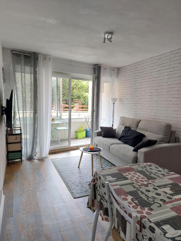 un salon avec un canapé et une table dans l'établissement Studio capacite 2 personnes quartier corniche a quelques pas des plages et petit centre ville, à Sète