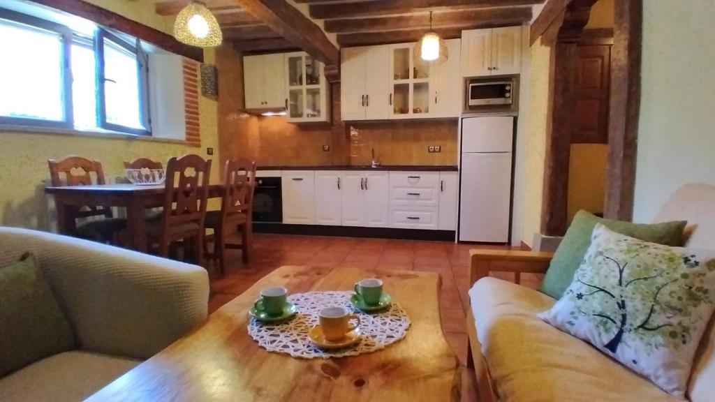 una sala de estar con una mesa con dos tazas. en Casa Rural Espeñitas, en La Alberca