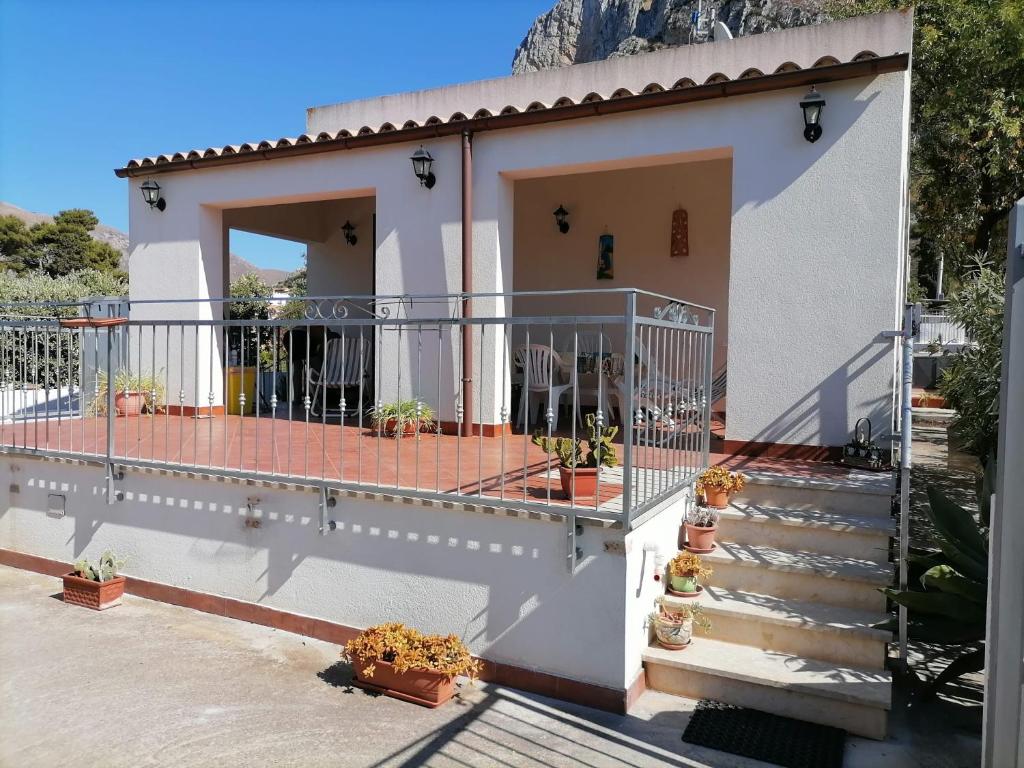 ein weißes Haus mit einem Balkon mit Topfpflanzen in der Unterkunft La casa di Agata in San Vito lo Capo