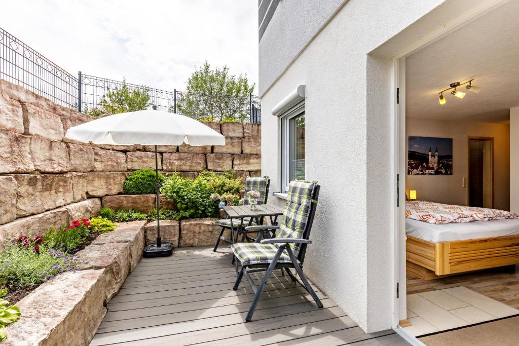 a patio with a table and chairs and an umbrella at Ferienwohnung Alpenblick in Zwiefalten