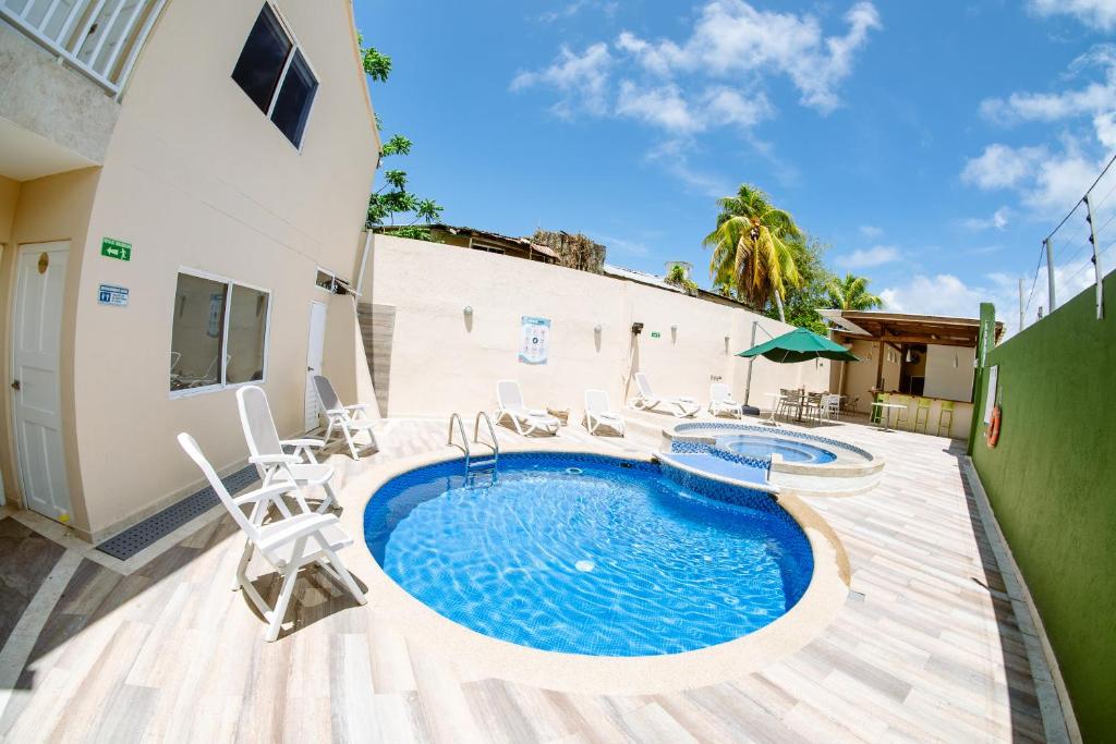 聖安德烈斯的住宿－Hotel Isla Bonita，一个带游泳池和椅子的庭院和一座建筑