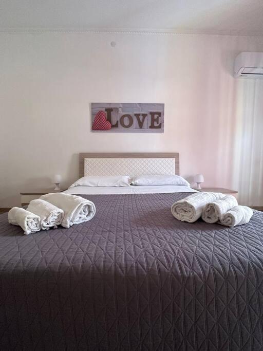 - une chambre avec 2 lits et des serviettes sur le lit dans l'établissement Passìu House, à Palerme