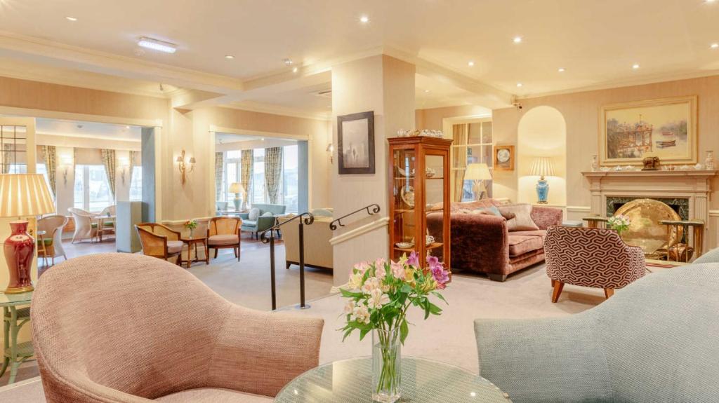 a living room filled with furniture and a fireplace at Wentworth Hotel in Aldeburgh