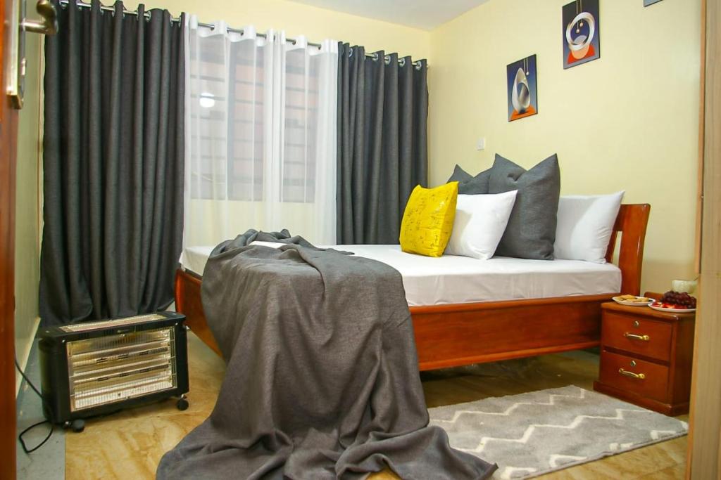 a bedroom with a bed and a window at Jaymorgan' cabins in Nyeri