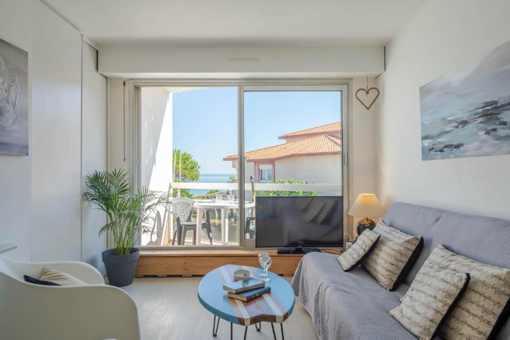 a living room with a couch and a large window at Studio vue sur l'océan in Anglet
