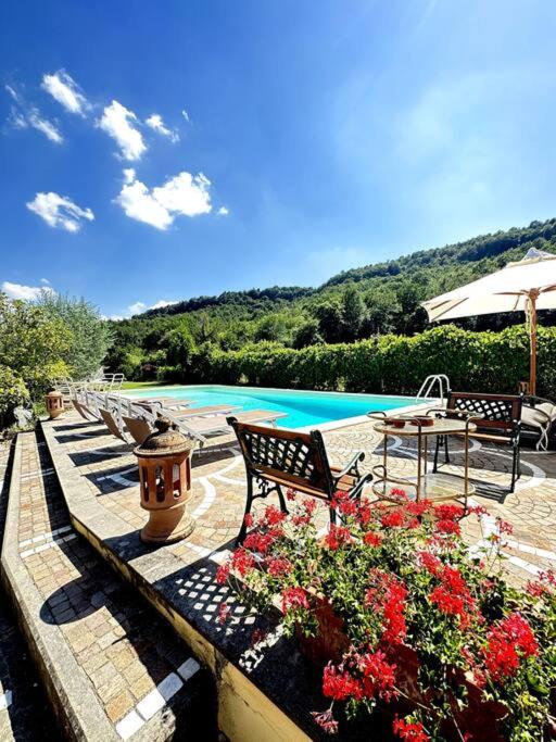a patio with benches and flowers and a pool at La Casetta in Orvieto Scalo
