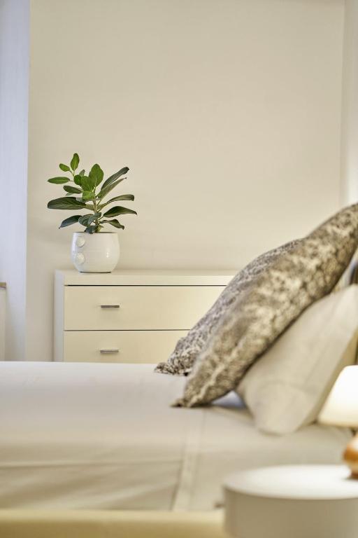 a bed with pillows and a potted plant on it at Casa Monelli in Siena
