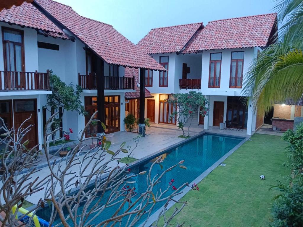 a villa with a swimming pool in front of a house at Elshape Holiday VILLA in Masjid Tanah