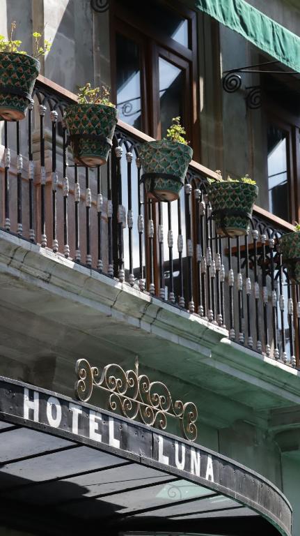 einen Balkon mit Topfpflanzen auf einem Gebäude in der Unterkunft Hotel Luna in Guanajuato