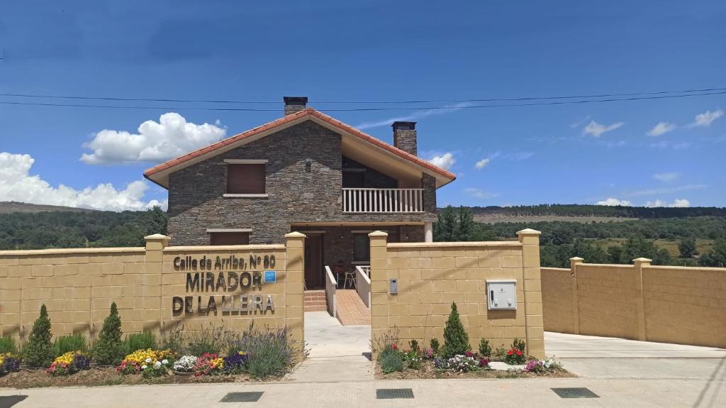 un bâtiment avec un panneau devant une clôture dans l'établissement El Mirador de la LLeira, à Ferreras de Arriba