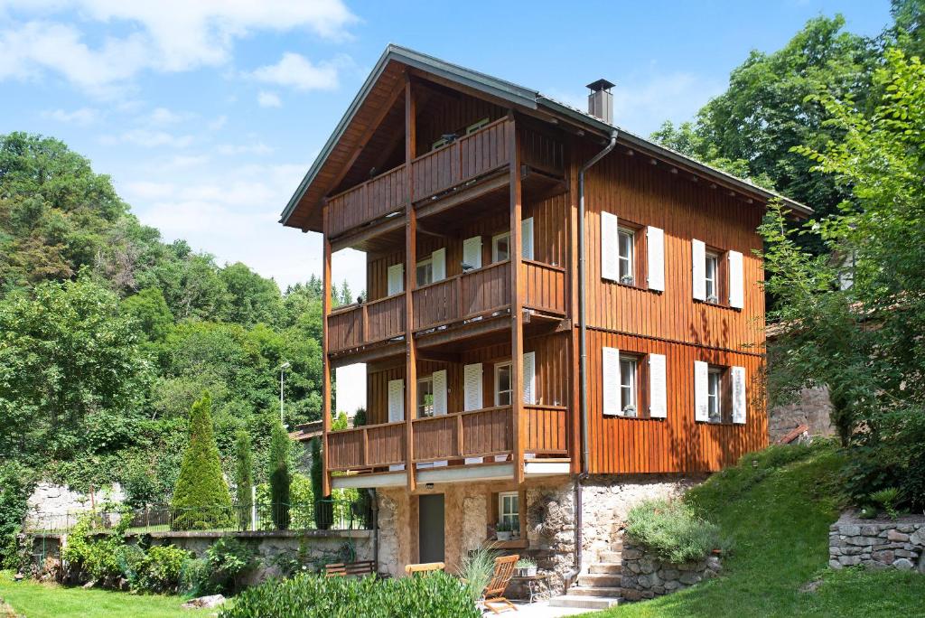 una casa de madera en una colina con árboles en Gutenburghüsli mit Garten am Fluss, en Waldshut-Tiengen