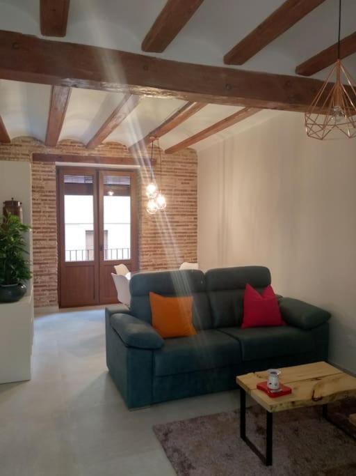 a living room with a blue couch and a table at Apartamento con encanto Ripalda VALENCIAYOLE in Valencia