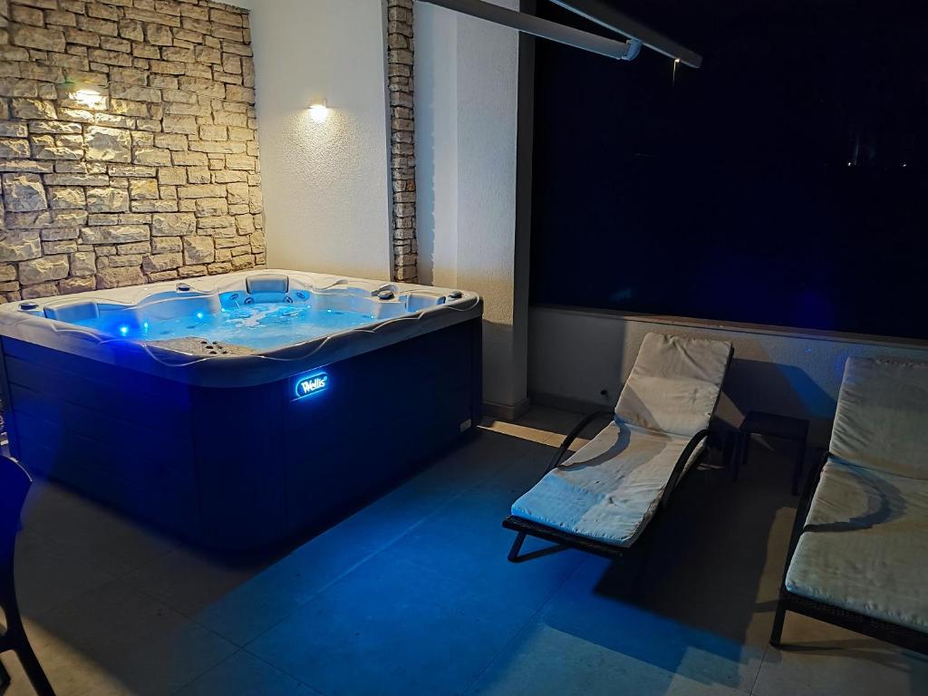 Astramaris Apartments في أوكرونغ دونغي: حوض أزرق في غرفة مع طاولة وكرسي