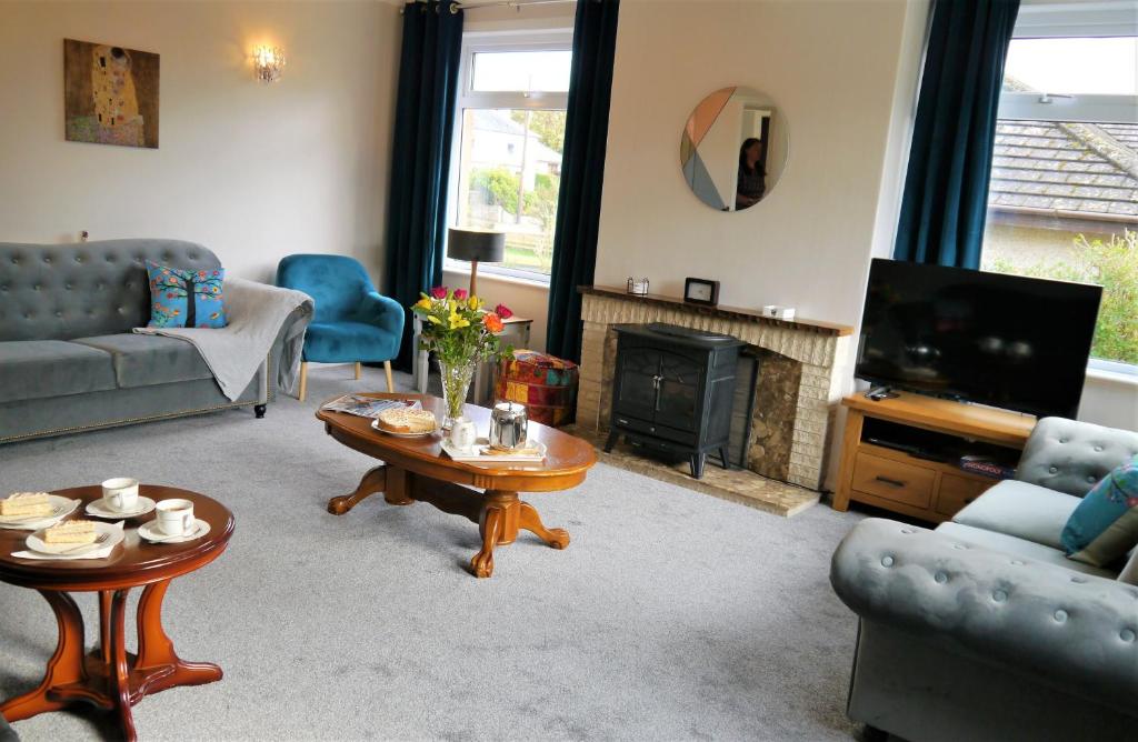 a living room with a couch and a tv and a table at Braidwood in Castle Douglas