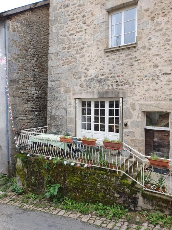 kamienny budynek z oknem i roślinami w obiekcie Studio St Jacques sur le chemin de pèlerinage w mieście Eymoutiers