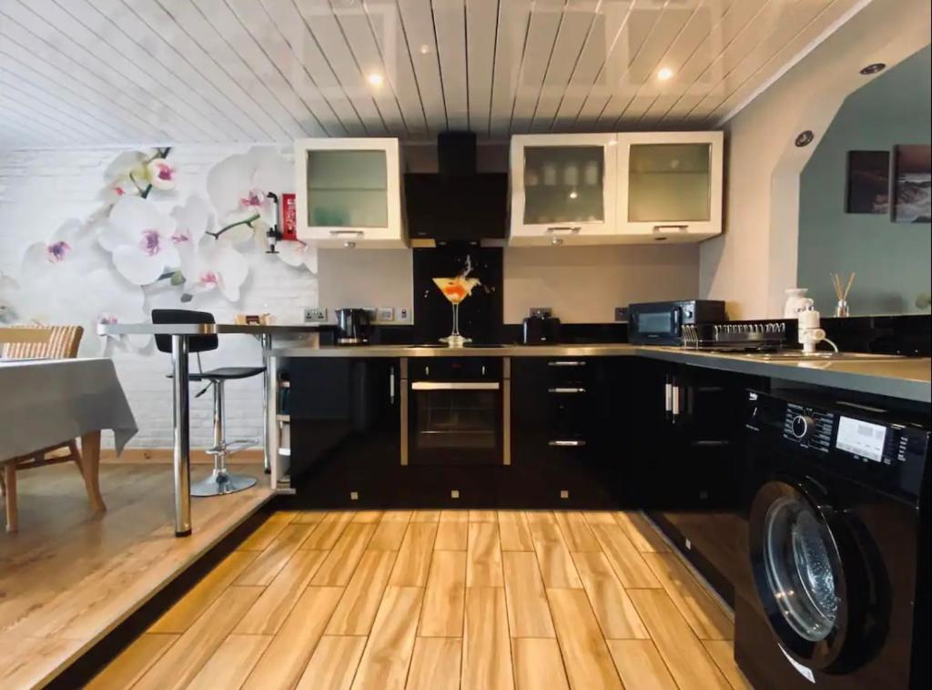 a kitchen with a washer and dryer in a room at Seasgair House in Balivanich