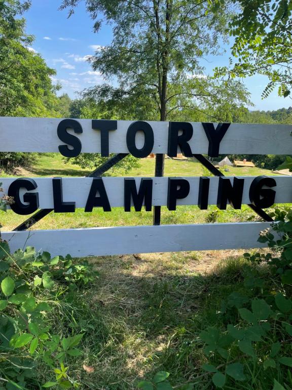 a sign that reads stop clapping on a white fence at STORY GLAMPING POLOVRAGI in Racoviţa