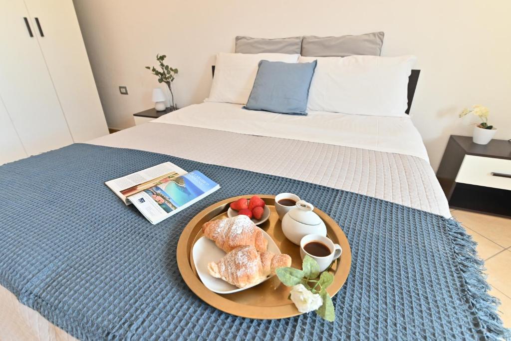 een dienblad met eten op een bed met een bord met eten bij IzzHome Flamingo in Pula