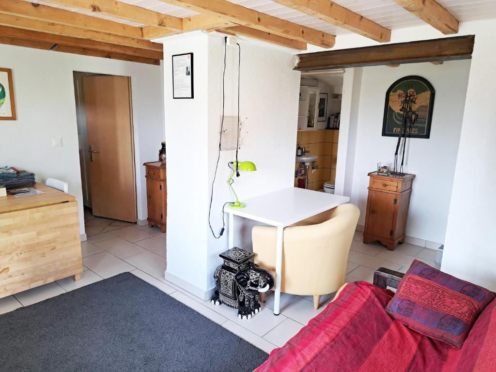 ein Wohnzimmer mit einem Tisch und einem Sofa in der Unterkunft "Les Echalas" Appartement indépendant avec cuisine en Lavaux Unesco in Chexbres
