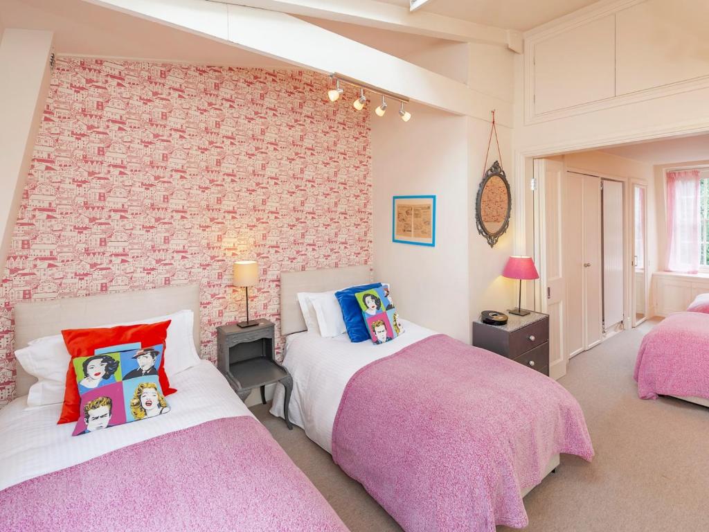 een slaapkamer met 2 bedden en een bakstenen muur bij Pass the Keys Luxury City Centre House in Bath
