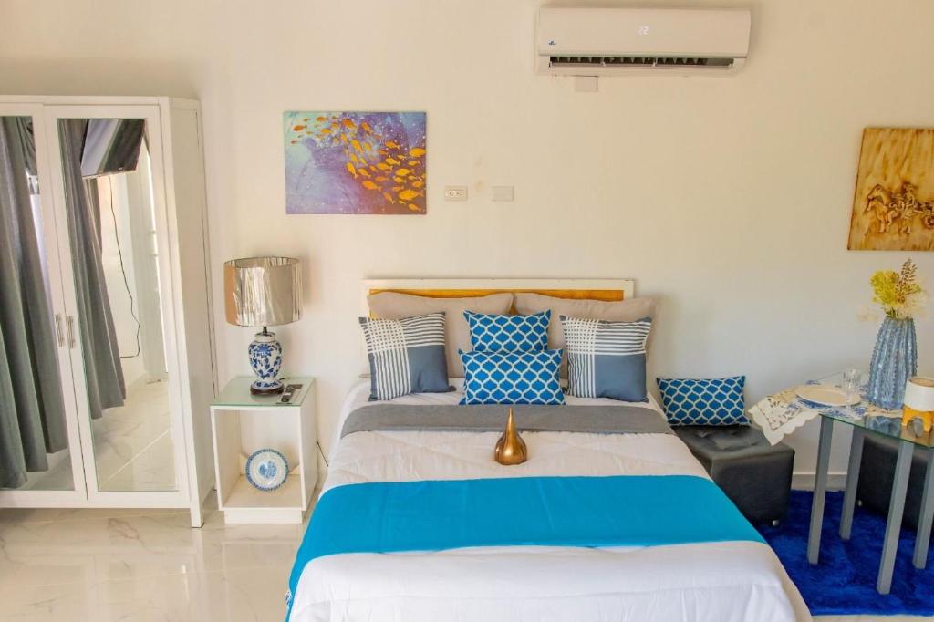 a bedroom with a bed with blue and white pillows at Royal Terrace III (Prince) in San Felipe de Puerto Plata