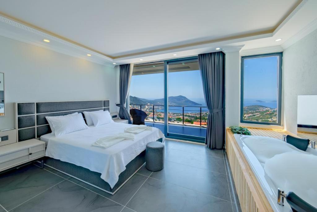 a hotel room with two beds and a large window at Hadi Villa in Kalkan