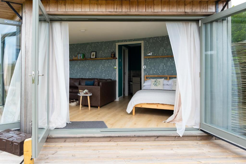 a bedroom with a bed and sliding glass doors at Daisy Bank Camp in Hebden Bridge